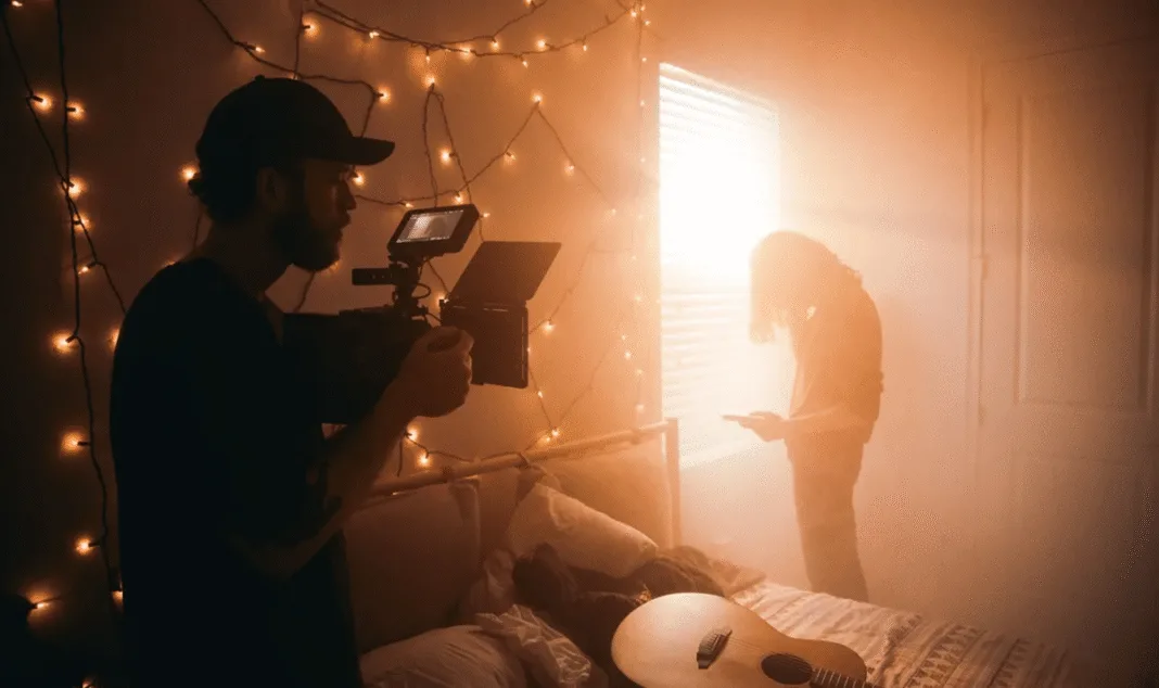 Cameraman filming a creative indoor scene with warm lighting and artistic atmosphere for a brand or media project.
